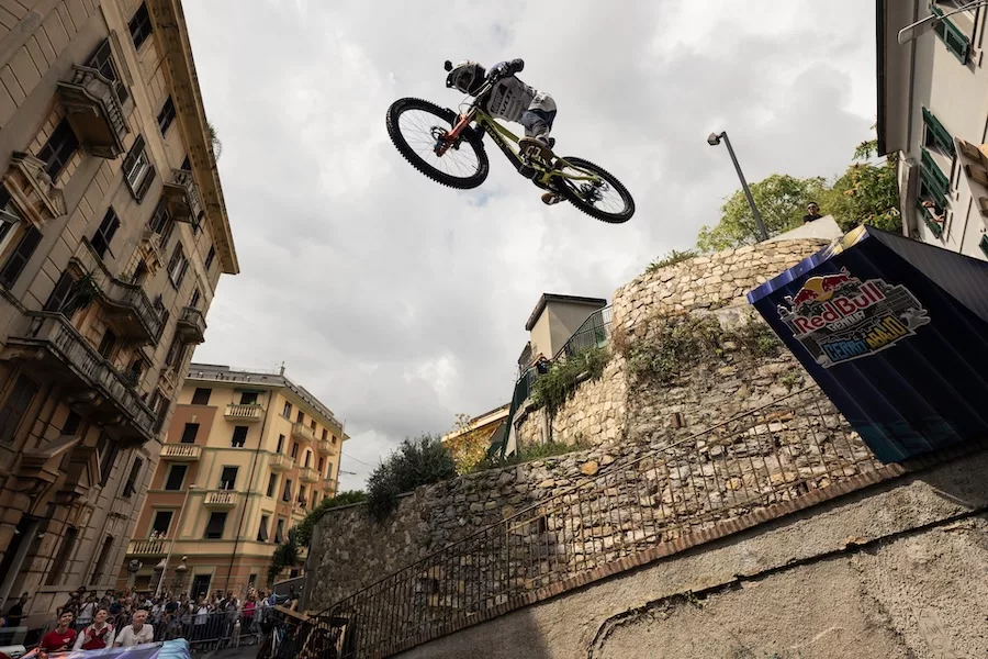 Uno dei salti spettacolari del tracciato genovese: la bici si alza sopra i tetti mentre la città continua intorno, indifferente.