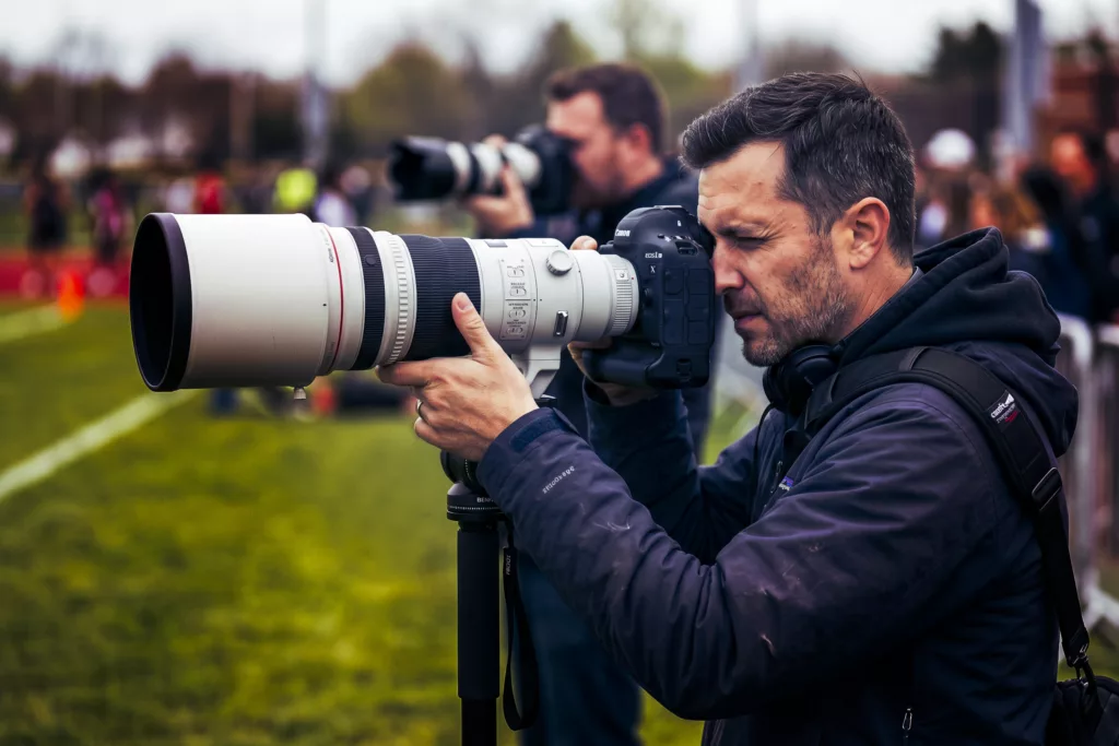 Fotografo, bordo campo con intero obiettivo, zoom