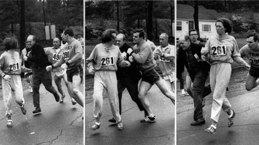 Kathrine Switzer, con il pettorale 261, corre durante la Maratona di Boston mentre l'organizzatore Jock Semple, in abiti civili, cerca di strapparle il numero. Un altro corridore interviene per fermarlo